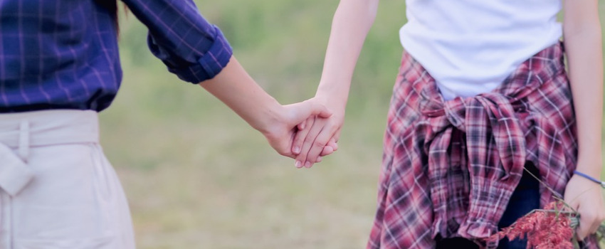 Two women holding hands.