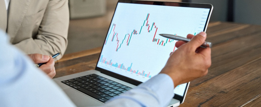 A man reviewing stock market movements on a laptop.