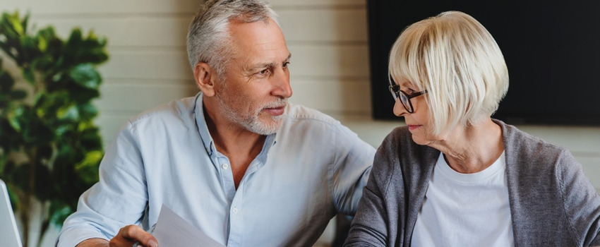 A mature couple talking and looking at paperwork together
